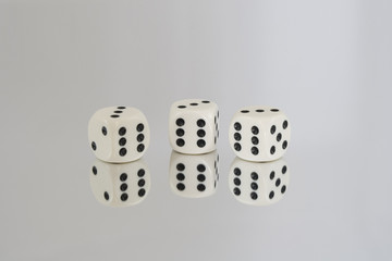 Three White dice with Black spots and reflections