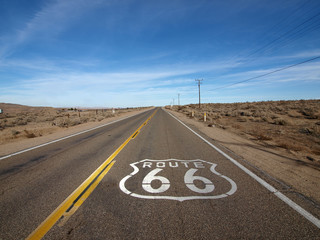 Historic Route 66 highway with pavement sign in the Mojave Desert area of Southern California.