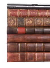 Old leather bound books with a laptop
