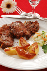 Grilled meat with baked potatoes and vegetable salad