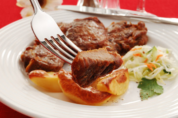 Grilled meat with baked potatoes and vegetable salad