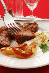 Grilled meat with baked potatoes and vegetable salad
