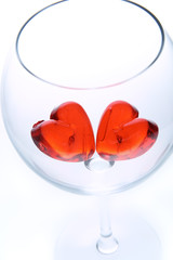 red jelly hearts in wine glass over white background