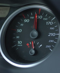 car speedometer with red arrows on black, horizontal