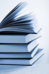 pile of books with one book open