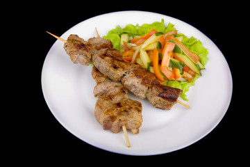 pork on a grill spit with salad