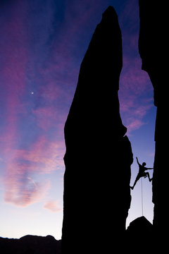 Rock climber reaching across a gap.
