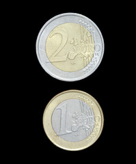 Currency coins of two and one Euro on black background
