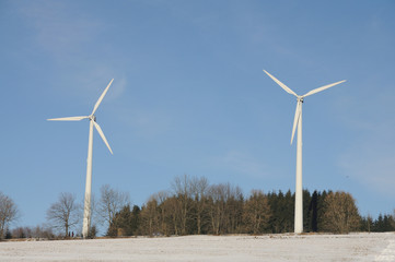Two wind turbines in wintery landscape