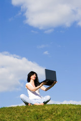 pretty woman with laptop on the green grass