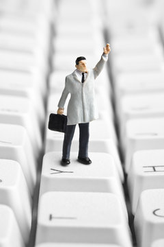 Businessman figurine placed on computer keyboard