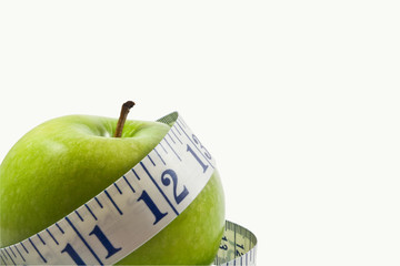 single green apple wrapped by a measuring tape