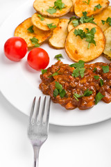 roasted potatoes with meat tomato sauce and two cherry tomatoes