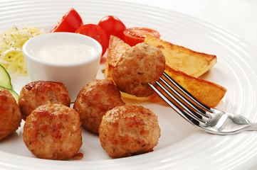 Fried meatballs with chips and vegetable salad