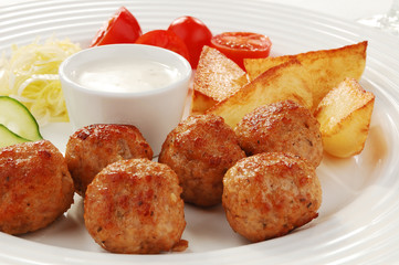 Fried meatballs with chips and vegetable salad