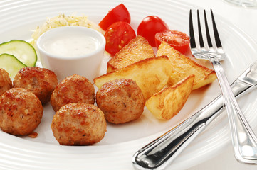 Fried meatballs with chips and vegetable salad