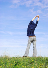 woman stretching on a grass hill