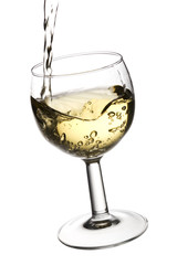White wine being poured into a glass, isolated on white