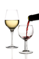 Red wine being poured into a glass and a glass of white wine