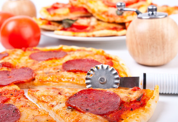 salami pizza with a pizza knife, pizza margherita, pepper-mil