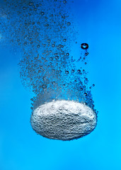 Effervescent tablet in water with bubbles - obrazy, fototapety, plakaty