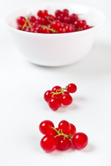 a bowl of redcurrants with one close up in front