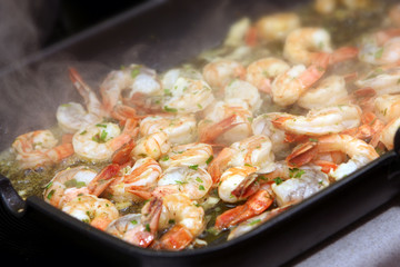 The photograph of fried seafood on the frying pan (shrimps)