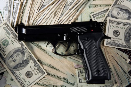 Dollar notes and gun, black pistol