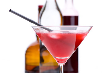 Cosmopolitan - Detail mit Trinkhalm vor Flaschen