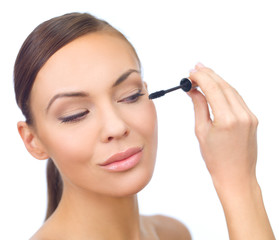 Fototapeta premium Portrait of beautiful woman doing makeup, on white