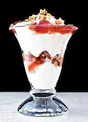 Parfait with strawberry sauce, granola and vanilla yogurt.