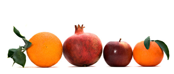 Pomegranate, orange, tangerine, and apple isolated on white back