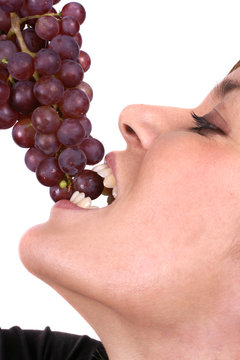 Beautiful Young Woman Eating Red Grapes