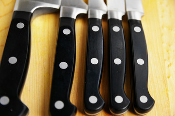 array of kitchen knives on a cutting board