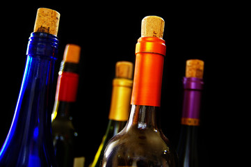 variety of wine bottles and corks on dark background