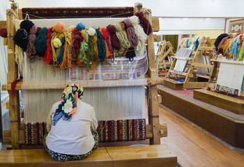 The woman behind work - weaving a carpet of silk.