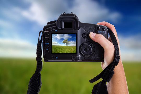 woman taking a landscape photography with a digital photo camera