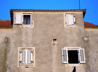 Fototapeta na wymiar wall with four windows two of wich is open