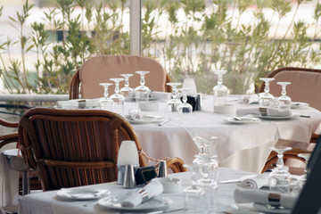 Tables with goblets and napkins inside restaurant