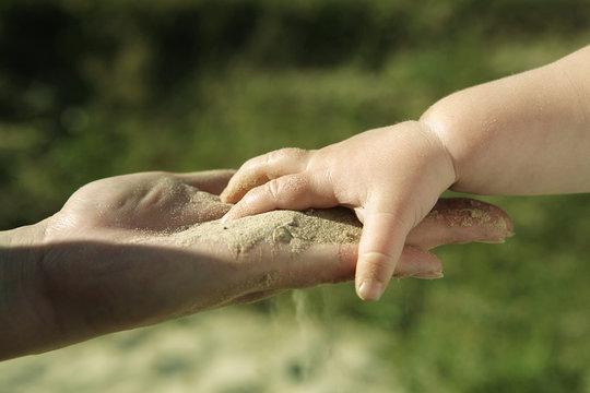 Baby hand with sand