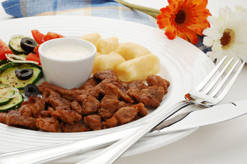 Grilled meat, dumplings and vegetable salad
