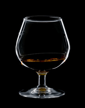 glass of cognac isolated over black background