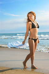 Naklejka premium beautiful girl goes for a walk on a coast