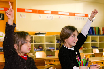 fillettes levant le doigt en classe