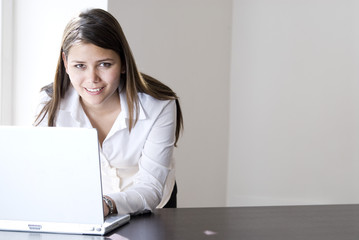 geschäftsfrau im büro lachend mit notebook