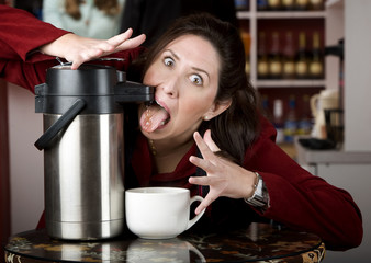 Woman drinking coffee directly from a dispenser