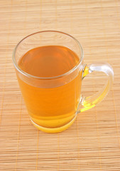 Glass cup of tea on wooden placemat