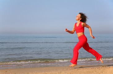 Young woman runs on shore of sea