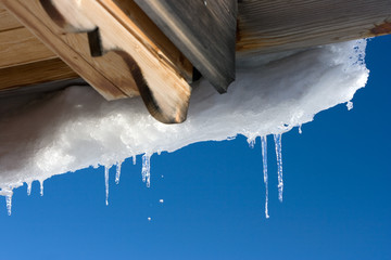 Wooden roof and icicles. Winter.