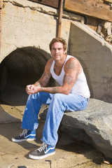 Man with Tattoos siiting on a Rock